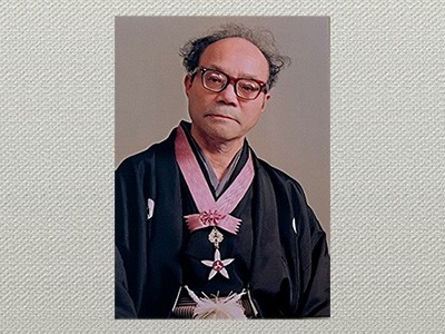 《文化勲章を胸にした棟方志功（展覧会会場で展示された写真）》